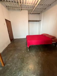 a large room with a red bed in it at Taroland in Máncora