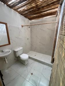 a bathroom with a toilet and a sink at Taroland in Máncora