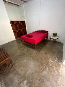 a room with a red bed and a chair at Taroland in Máncora +8 photos
