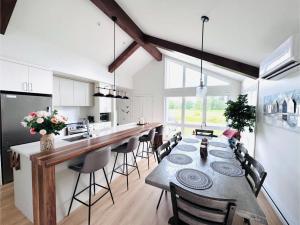 a kitchen and dining room with a long table and chairs at Kaïros - Private Spa & Golf Getaway in Saint-Basile