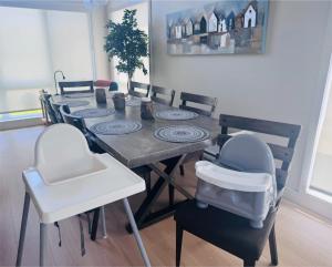 a dining room with a table with chairs and a baby seat at Kaïros - Private Spa & Golf Getaway in Saint-Basile