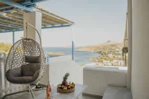 a chair on a balcony with a view of the ocean at Monopetra View 2 Leros in Nisís Léros