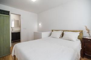リスボンにあるLittle duplex in Alfamaのベッドルーム(白いベッド1台付)、バスルーム
