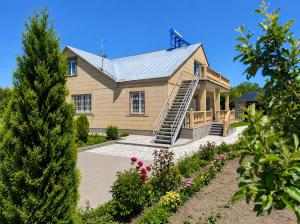 a house with a staircase in front of a yard at Guest House Chkalovka Garden in Sevan