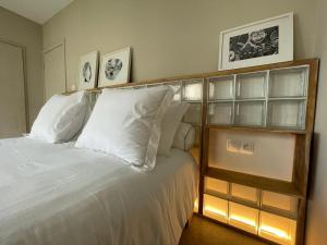 a bedroom with a bed with white pillows at Nomads Kodjoviakopé in Lomé