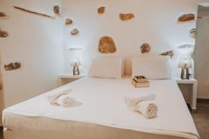 a bedroom with a white bed with towels on it at Monopetra View 2 Leros in Nisís Léros