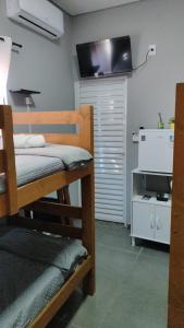 a bedroom with a bunk bed with a tv on the wall at Recanto da Matriz - Águas da Prata in Águas da Prata