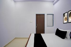 a bedroom with a bed and a brown door at Hotel O AVS Inn in Bheta