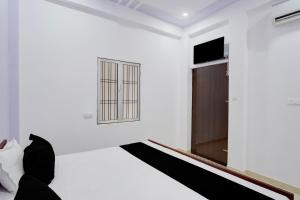 a white room with a window and a bed at Hotel O AVS Inn in Bheta