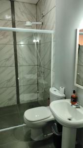 a bathroom with a shower and a toilet and a sink at Recanto da Matriz - Águas da Prata in Águas da Prata +24 photos