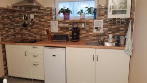 a kitchen with white cabinets and a sink at Kitti Szálláshely in Mogyoród