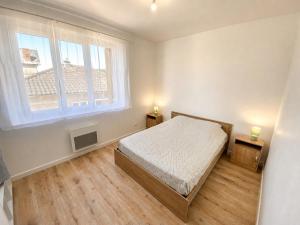 a bedroom with a bed and a large window at La Maison du Clain in Jaunay-Clan