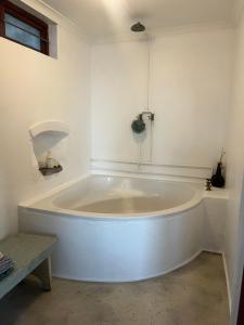 a large white bath tub in a white room at Rondawel with sea view in Kleinmond