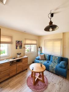 a living room with a blue couch and a table at Domek letniskowy Sarnowo, Skępe in Skępe