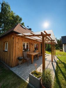 a wooden cabin with a table and a wooden umbrella at Domek letniskowy Sarnowo, Skępe in Skępe +13 photos
