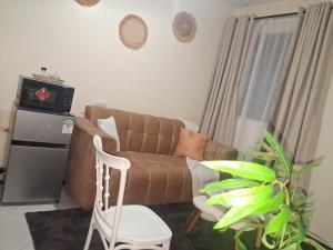 a living room with a brown couch and a plant at Town Stays in Voi +24 photos