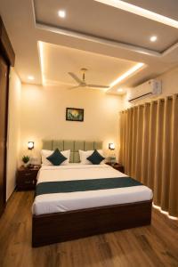 a bedroom with a large bed with blue pillows at Hotel Royal Villa in Nagpur