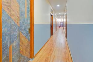 a hallway with a wooden floor and a glass door at Hotel O Moonlight Luxury Rooms in Kāmāreddi