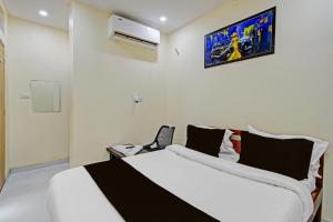 a bedroom with a large white bed with black pillows at Hotel O Moonlight Luxury Rooms in Kāmāreddi
