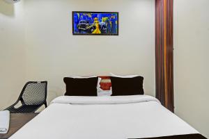 a bedroom with two beds and a chair at Hotel O Moonlight Luxury Rooms in Kāmāreddi +65 photos