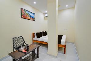 a room with a bed and a table and a couch at Hotel O Moonlight Luxury Rooms in Kāmāreddi