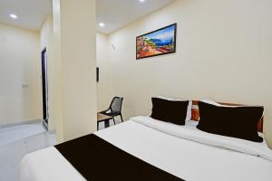 a bedroom with a bed and a chair at Hotel O Moonlight Luxury Rooms in Kāmāreddi