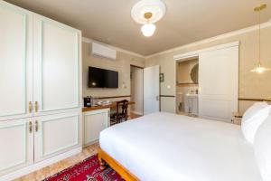 a bedroom with a white bed and a desk at Royva Bo-Kaap in Cape Town