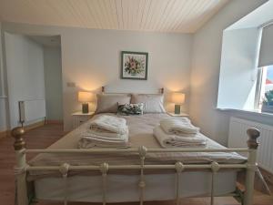 a bedroom with a large bed with blankets and pillows at Maggies Cottage in Manorhamilton