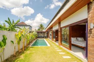 a backyard with a swimming pool and a house at Villa Sandhyā Tabanan in Tabanan