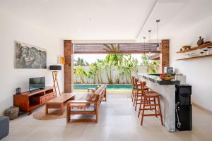 a kitchen and living room with a bar and chairs at Villa Sandhyā Tabanan in Tabanan