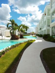 a walkway in front of a resort with a swimming pool at Bora 102 Garden Breeze 1 in La Laguna