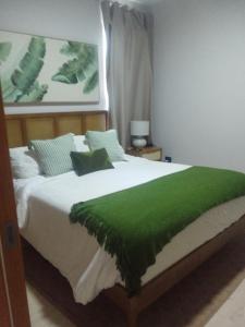 a bedroom with a green blanket on a bed at Bora 102 Garden Breeze 1 in La Laguna +15 photos