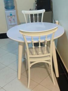a white table and a chair sitting next to a table at PAZURI - Homes in Voi