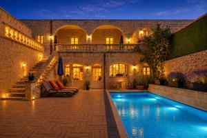 a house with a swimming pool in the yard at Ta' Matmura Boutique B&B in Għarb