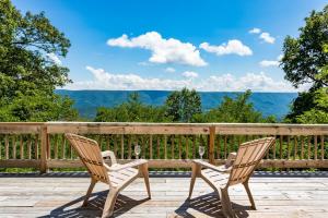 two chairs and a table on a deck with a view at 3BR cabin w scenic deck and pet-friendly in Great Cacapon