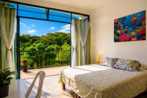 a bedroom with a bed and a large window at Casa Esperanza in Playa Estacahuite