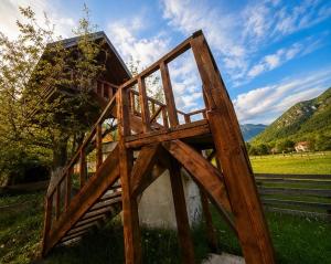 a wooden structure in a field with mountains in the background at TreeHouse Experience in Vusanje