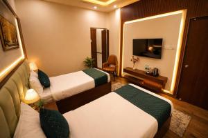 a hotel room with two beds and a television at Hotel Royal Villa in Nagpur +11 photos
