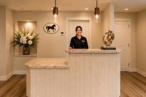 a woman standing behind a counter in a room at Wayside Inn in Carmel