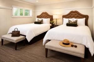 a bedroom with two beds and a hat on a chair at Wayside Inn in Carmel +26 photos