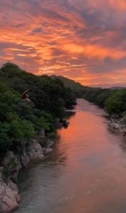 a river with a sunset in the background at Hotel Boutique Trinitarias in Valledupar