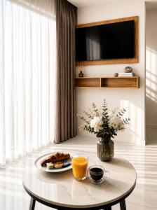 a coffee table with a plate of food and orange juice at Villa Lancana in Zvekovica