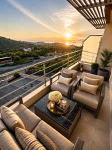 a balcony with a couch and chairs and a sunset at Villa Lancana in Zvekovica