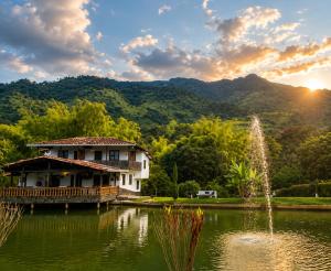 a house in the middle of a pond with a fountain at Hotel Campestre Alameda in Támesis
