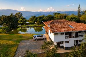 a car parked in front of a house with a lake at Hotel Campestre Alameda in Támesis