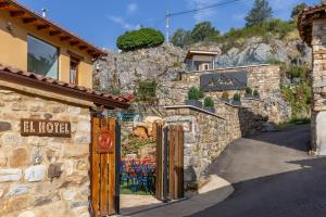 a stone building with a gate in front of a mountain at El Hotel & SPA de Verdiago in Verdiago
