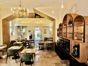 a restaurant with tables and chairs and a chandelier at Generalis Wine Hotel in Tokaj