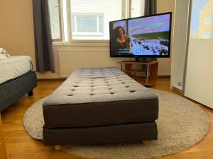 a ottoman sitting in a living room with a television at Malmi Home in Vaasa