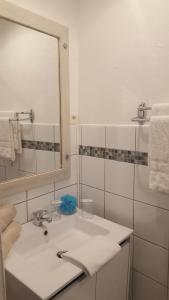 La salle de bains blanche est pourvue d'un lavabo et d'un miroir. dans l'établissement Hôtel Auberge Provençale, à Saint-Raphaël