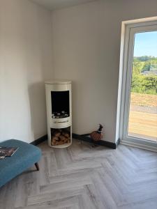 a room with a large window and a chicken sitting on the floor at Swallows Lodge in Bathgate
